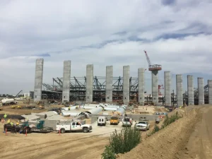 Large-scale stadium construction site featuring seismic foundation support structures.