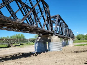 Corrugated structural plate installed around existing railroad bridge piers as permanent concrete forms.